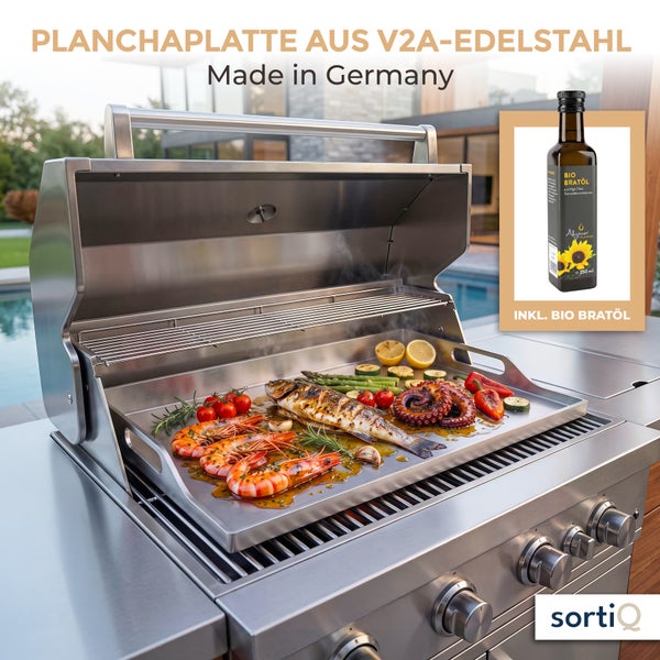 Edelstahl Planchaplatte auf einem Gasgrill mit gebratenem Fisch, Garnelen und Gemüse sowie inklusive Bio Bratöl.
