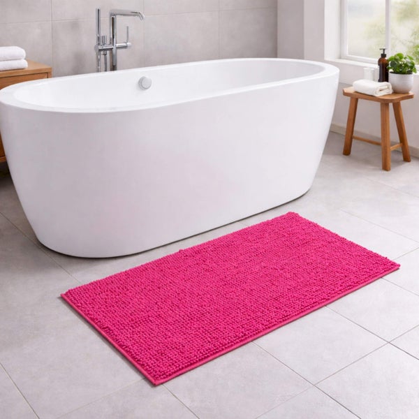 Strukturierter pinker Badeteppich in einem modernen Badezimmer vor einer freistehenden Badewanne.