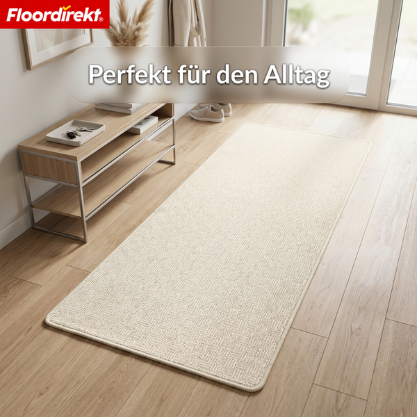 Floordirekt Logo. Strukturierter Teppichläufer in einem hellen Flur auf Holzboden neben einer Konsole mit Dekoration.