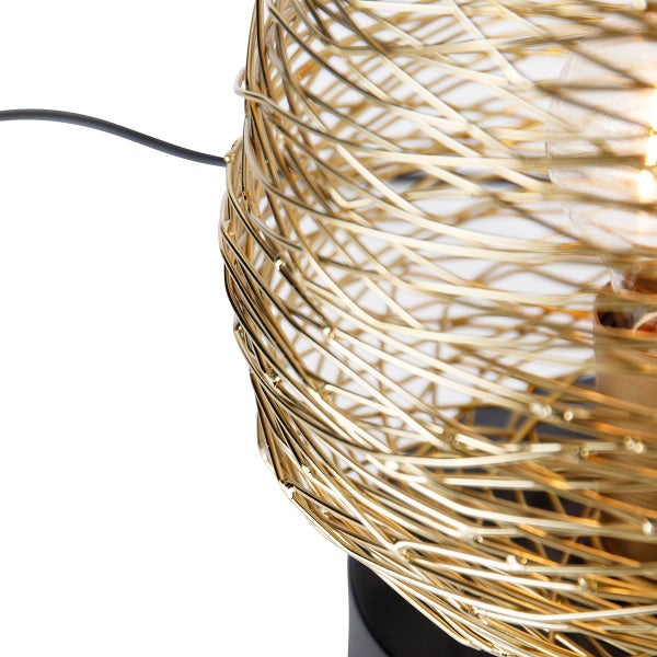 Detailansicht einer Tischleuchte mit einem Lampenschirm aus goldenem Metalldraht