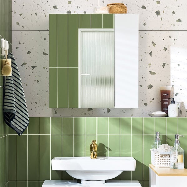 Badezimmer mit Waschbecken, Spiegelschrank und grünen Fliesen