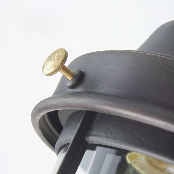 Detailaufnahme einer schwarzen Wandleuchte mit goldener Schraube