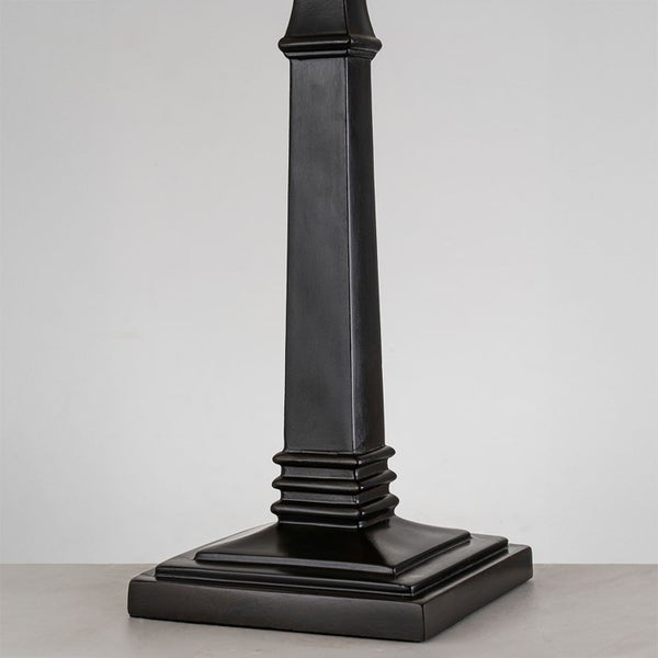 Detailaufnahme eines dunklen Lampenfußes aus Holz.