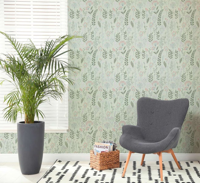 Wohnzimmer mit Blumentapete mit botanischem Muster, einem Sessel, einer Zimmerpflanze und einem Korb vor einem Fenster mit Jalousien.