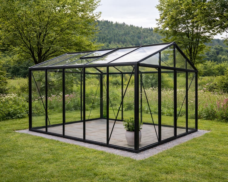 Modernes Gewächshaus mit Glaspaneelen und schwarzem Metallrahmen auf einem gepflasterten Fundament in einem Garten.