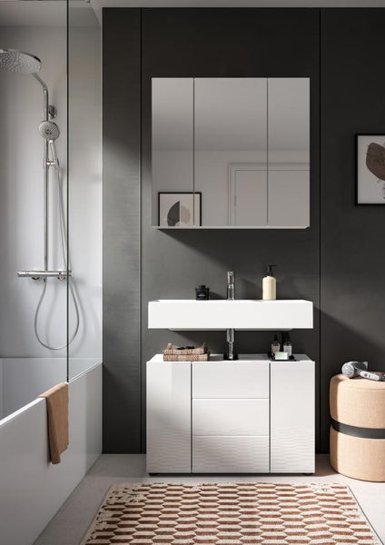 Modernes Badezimmer mit weißem Waschtischunterschrank, rechteckigem Waschbecken und Spiegelschrank vor dunkler Wand neben einer Badewanne mit Dusche.
