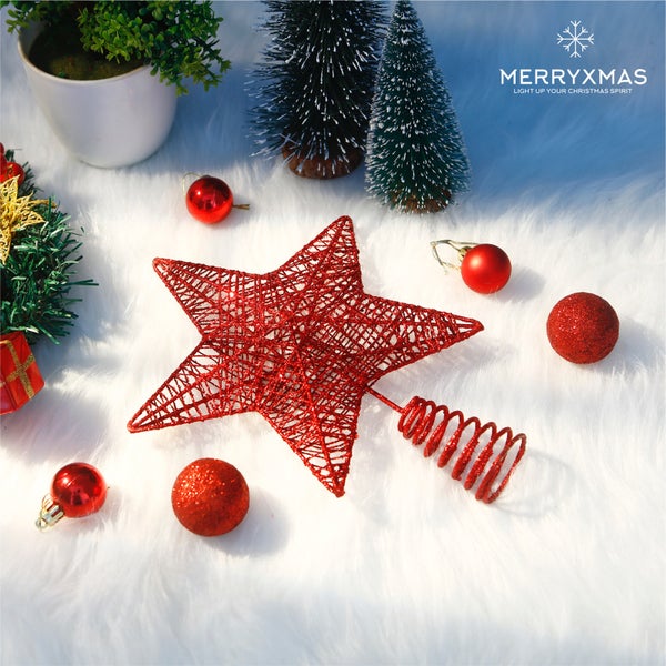 Dekorative Weihnachtsszene mit rotem Stern, Weihnachtskugeln und kleinen Tannenbäumen