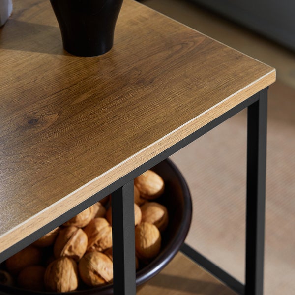 Detailansicht eines Beistelltisches mit Holzplatte und Metallgestell, darunter eine Schale mit Nüssen