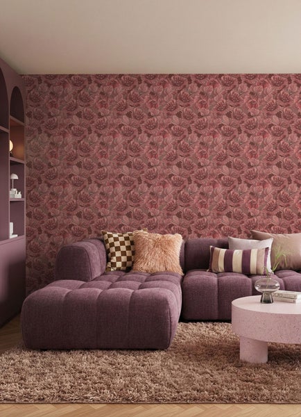 Wohnzimmer mit floraler Tapete, lila Sofa und Teppich