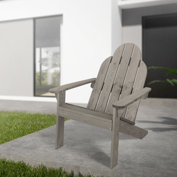 Ein grauer Adirondack Gartenstuhl aus Holz auf einer Terrasse vor einem modernen Wohnhaus.