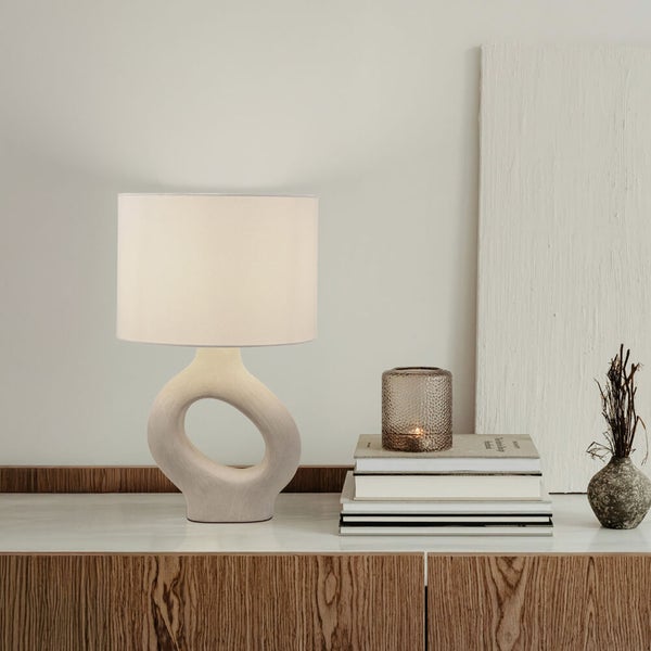Dekorative Tischleuchte auf einem Sideboard mit Kerzen und Büchern