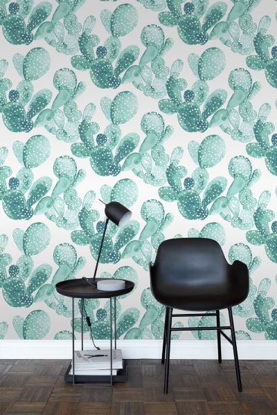 Wohnraum mit Kaktusmuster-Tapete, Tisch und Stuhl.