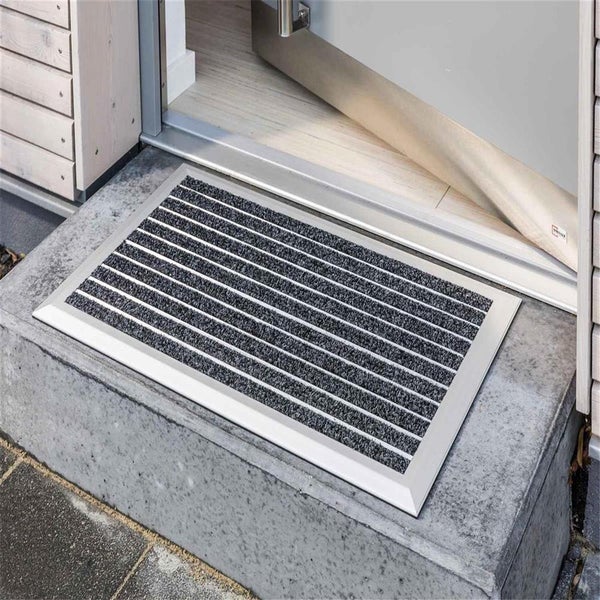 Fußmatte mit Aluminiumrahmen vor einer Haustür