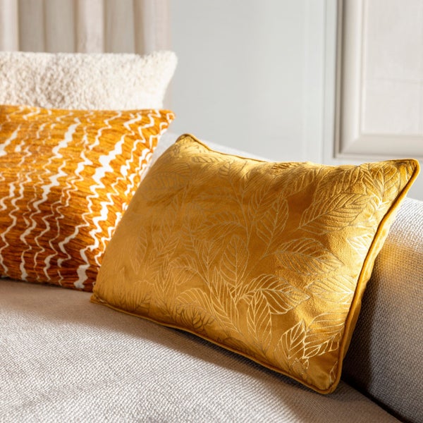 Dekorative Kissen mit Blattmuster und Zickzackmuster auf einem Sofa