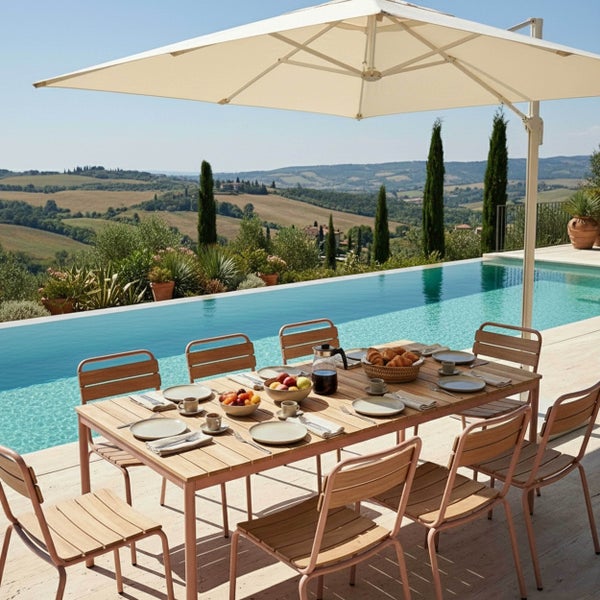 Moderner Gartentisch und Stühle aus Holz und Metall neben einem Pool mit Sonnenschirm und Blick auf eine hügelige Landschaft.