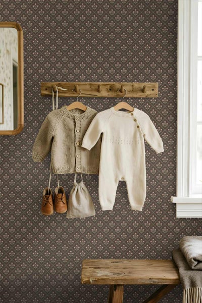 Vliestapete mit kleinem floralem Muster in Rosa auf dunklem Grund, kombiniert mit einer Holzgarderobe und Kinderkleidung in einem Kinderzimmer.