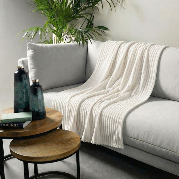 Wohnzimmer Szene mit Sofa, Decke, zwei Vasen und Beistelltisch