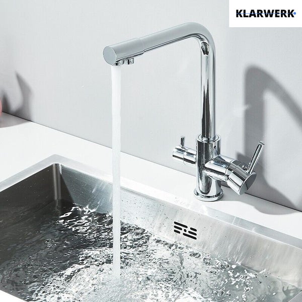 Moderne Küchenarmatur aus Chrom mit drei Griffen und L-Auslauf, fließendes Wasser in eine Edelstahlspüle. Klarwerk Logo.