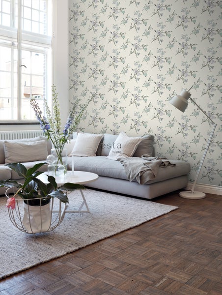 Wohnzimmer mit Sofa, Tisch, Stehlampe und Blumentapete