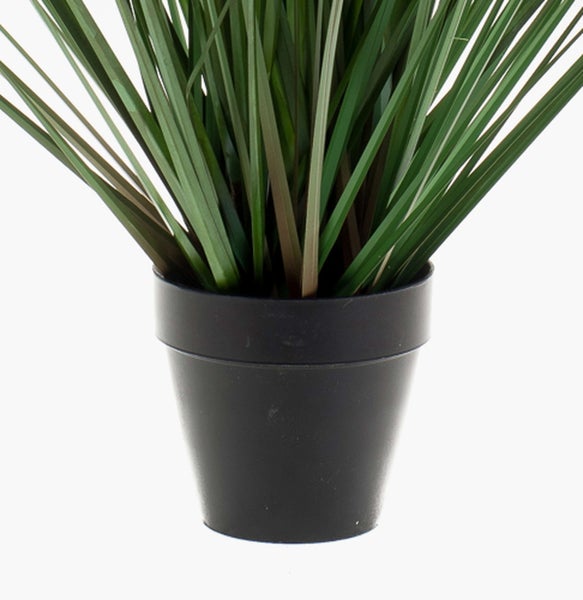 Künstliches Ziergras in einem schwarzen Kunststofftopf.