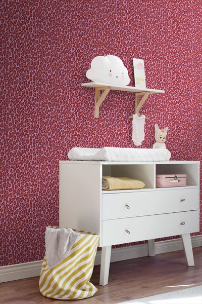 Vliestapete mit Leopardenmuster in einem Kinderzimmer mit weißer Wickelkommode und Wandregal.