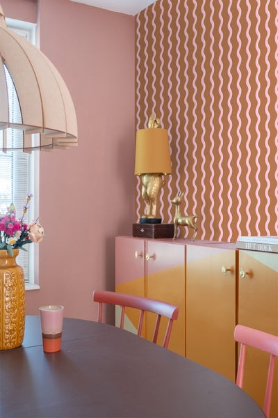 Esszimmer mit Esstisch, Stühlen, Sideboard und gemusterter Tapete