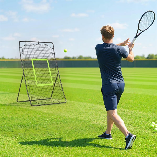 Ein Sportler schlägt einen Tennisball gegen ein freistehendes Rebound Netz auf einer grünen Rasenfläche.