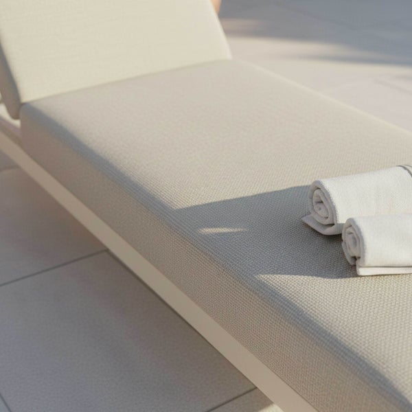 Moderne Gartenliege mit Metallgestell und beige gepolsterten Kissen.