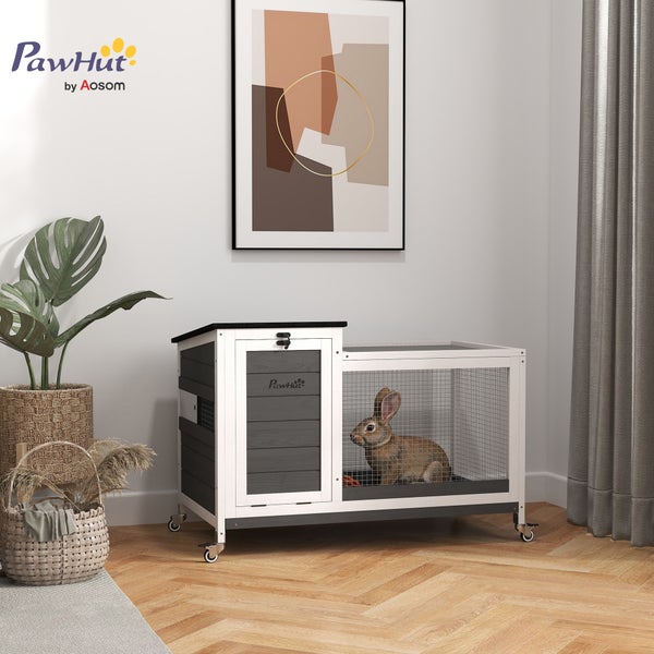 Mobiler PawHut Kleintierstall aus weiß-grauem Holz in hellem Wohnzimmer mit Parkett, Gittertür und Kaninchen sowie PawHut Logo.