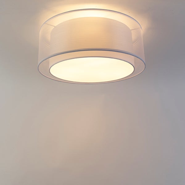 Runde Deckenleuchte mit zweilagigem Textilschirm, eingeschaltet.