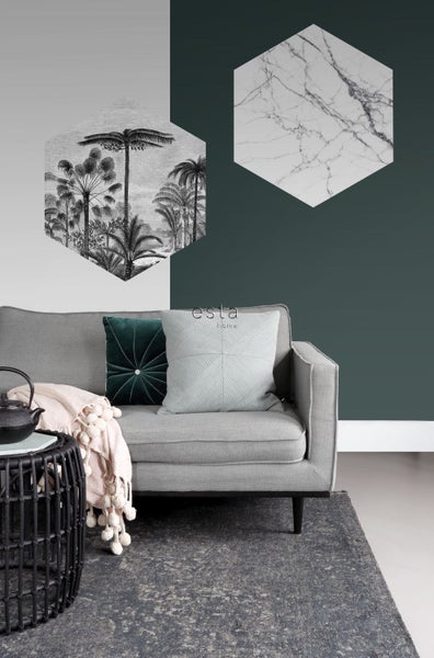 Wohnzimmer mit grauer Couch, Zierkissen, Teppich und hexagonalen Wanddekorationen mit Pflanzen- und Marmormotiven