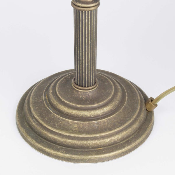 Detailaufnahme des Sockels einer Tischleuchte aus Metall mit geripptem Schaft.