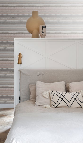 Schlafzimmer mit Bett, Kissen und dekorativen Vasen auf dem Kopfteil