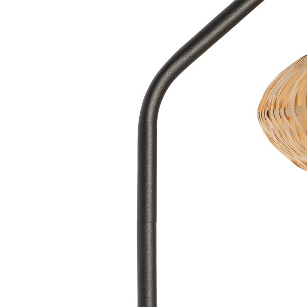 Detailansicht einer Stehlampe mit Metallgestell und Lampenschirm aus Rattan
