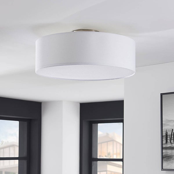 Runde Deckenleuchte mit weißem Textilschirm, montiert an einer hellen Decke in einem modern gestalteten Wohnraum.