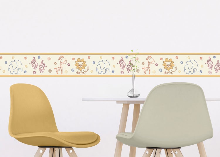 Selbstklebende Tapetenbordüre für das Kinderzimmer mit Tiermotiven, angebracht in einem hellen Raum über einem Tisch mit Stühlen.