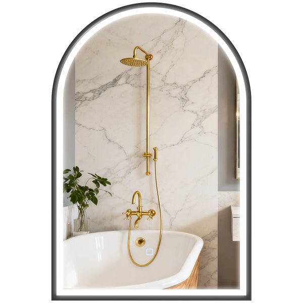 Bogenwandspiegel mit LED Beleuchtung in modernem Badezimmer mit freistehender Badewanne und goldener Duscharmatur vor Marmorwand