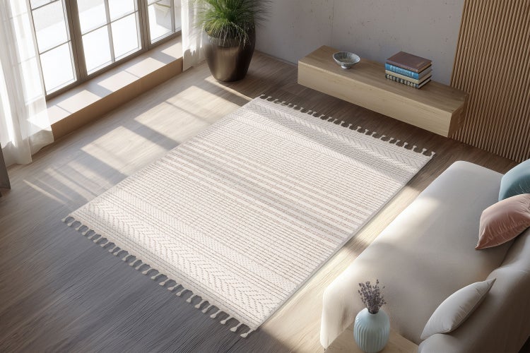 Wohnzimmer mit einem gemusterten Teppich mit Fransen, Holzboden, Sofa und Fenster in einer hellen, modernen Einrichtung.