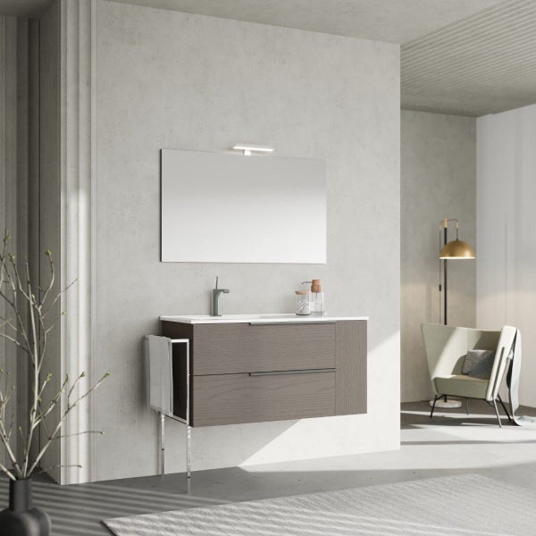Modernes Badezimmer mit Waschtischunterschrank aus Holz, integriertem Waschbecken, Spiegel mit Beleuchtung und Handtuchhalter an der Wand.