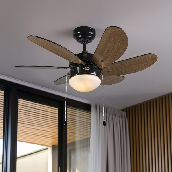 Deckenventilator mit Lampe und sechs Flügeln in Holzoptik sowie zwei Zugschaltern zur Steuerung in einem modern eingerichteten Raum.