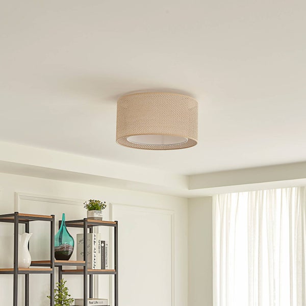 Runde Deckenleuchte mit Schirm aus Geflecht montiert an der Decke in einem hellen, modern eingerichteten Wohnzimmer.