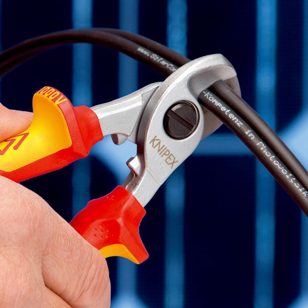 Knipex Kabelschere mit Knipex Logo und bis 1000 Volt isolierten Griffen beim Schneiden eines Photovoltaikkabels.