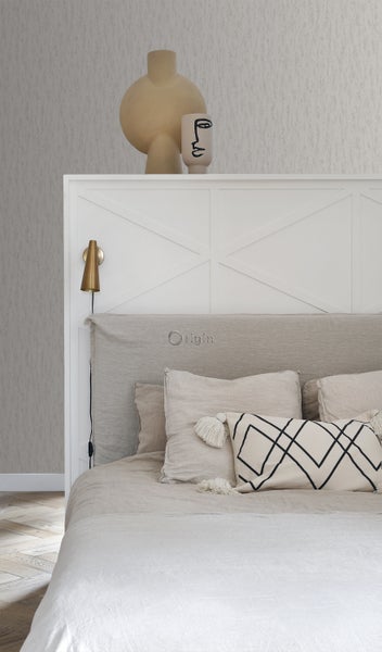 Schlafzimmer mit Bett, Kissen und dekorativen Vasen auf dem Kopfteil