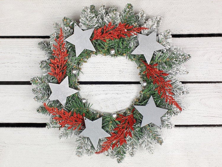 Weihnachtskranz mit künstlichen Tannenzweigen, Sternen und dekorativen Zweigen als weihnachtliche Wand oder Türdekoration.