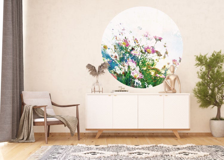Helles Wohnzimmer mit Sessel, Teppich, Kommode und kreisrundem Blumenwandbild