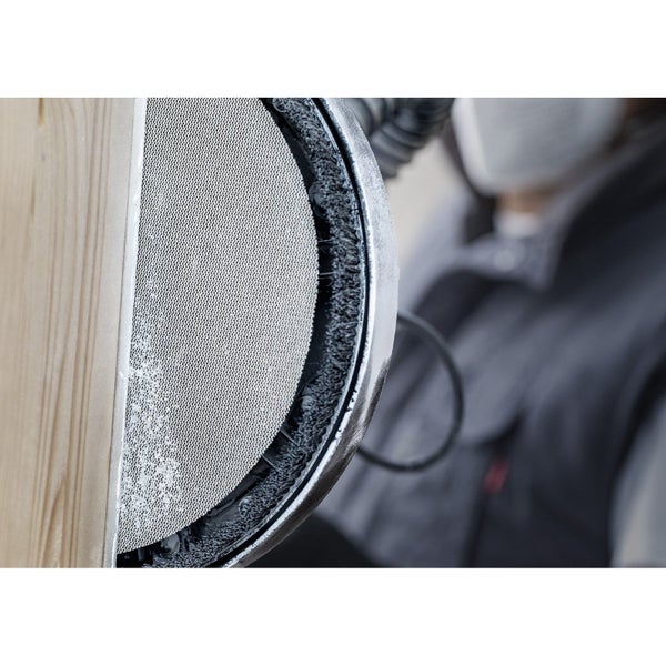 Detailaufnahme eines Schleifgeräts mit Schleifscheibe an einem Holzbrett