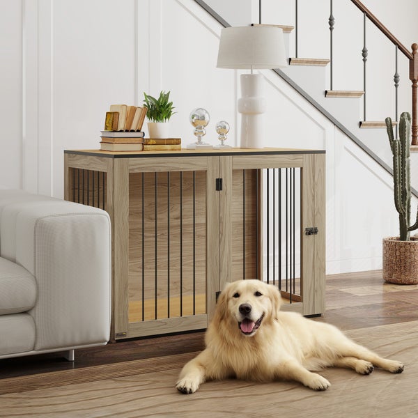 Hundekäfig im Sideboard-Design aus hellem Holzdekor mit schwarzen Metallstäben, dekoriert mit Lampe, davor ein liegender Golden Retriever.