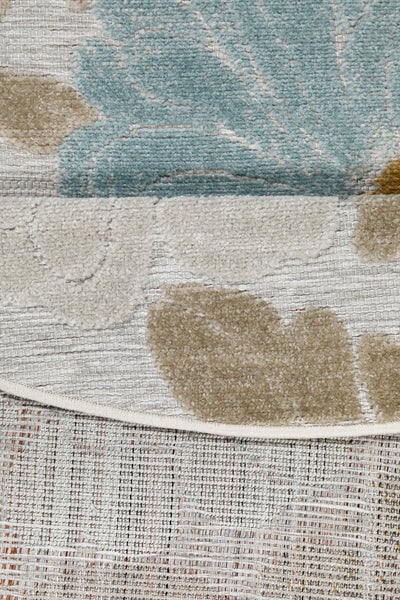 Detail eines runden Outdoor-Teppichs mit Blumenmuster, Flachgewebe und weichem Flor.