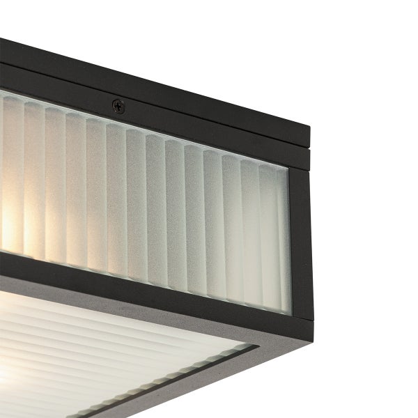 Detailansicht einer quadratischen Leuchte mit schwarzem Metallrahmen und geriffeltem Mattglas.