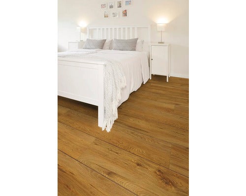 Modernes, helles Schlafzimmer mit Laminatboden in Eichenoptik, weißem Holzbett und passenden Nachttischen.
